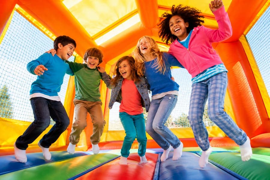 Kids jumping in a bounce house booked through an online rental reservation